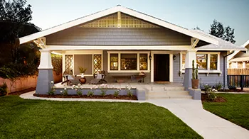 A sidewalk leads up to an one-story home with a front porch.